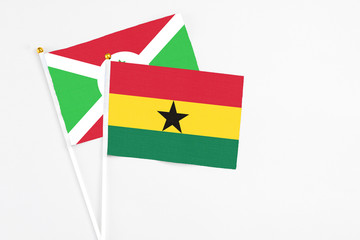 Ghana and Burundi stick flags on white background. High quality fabric, miniature national flag. Peaceful global concept.White floor for copy space.