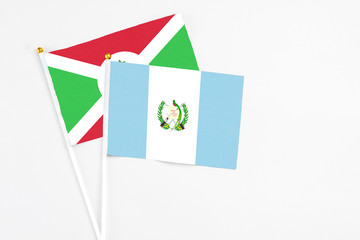 Guatemala and Burundi stick flags on white background. High quality fabric, miniature national flag. Peaceful global concept.White floor for copy space.