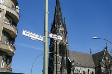 Street Signs of Südstern and Hasenheide with gothic church in background on a clear sunny day