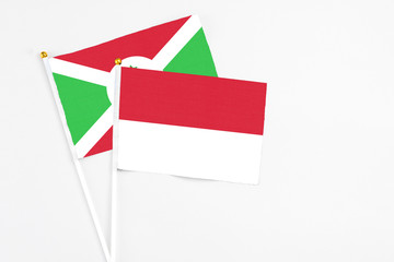 Indonesia and Burundi stick flags on white background. High quality fabric, miniature national flag. Peaceful global concept.White floor for copy space.