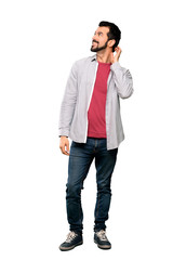 Full-length shot of Handsome man with beard thinking an idea over isolated white background