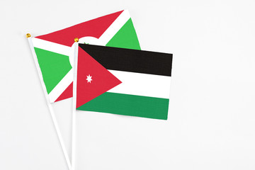 Jordan and Burundi stick flags on white background. High quality fabric, miniature national flag. Peaceful global concept.White floor for copy space.