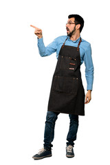 Full-length shot of Man with apron pointing away over isolated white background