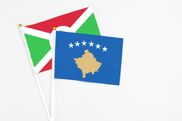 Kosovo and Burundi stick flags on white background. High quality fabric, miniature national flag. Peaceful global concept.White floor for copy space.