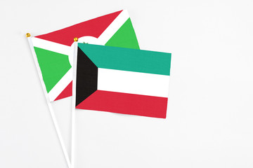 Kuwait and Burundi stick flags on white background. High quality fabric, miniature national flag. Peaceful global concept.White floor for copy space.