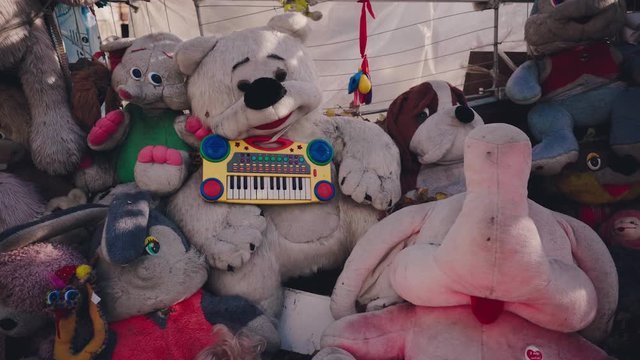 Old and battered soft toys lie on the street. The dump of the abandoned toys