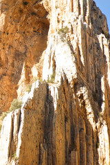 Brown red mountains shale steep cliffs near the trail, mountain trail along steep cliffs in Spain, Ardales the caminito caminito del rey. Tall red rocks mountain side in el Chorro
