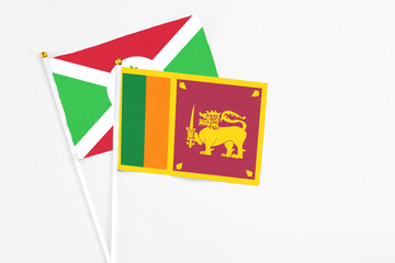 Sri Lanka and Burundi stick flags on white background. High quality fabric, miniature national flag. Peaceful global concept.White floor for copy space.