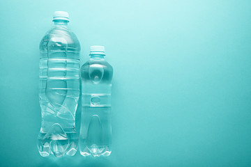 large and small plastic clean water bottles with copy space on neo mint background