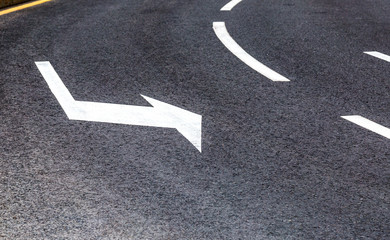 Traffic sign white arrow on asphalt road