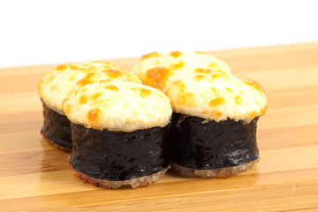 Hot sushi maki rolls on a wooden board.