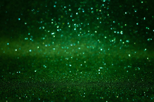 Green abstract glittering background. Defocused lights. Christmas greeting card. Christmas or New Year celebration concept. Copy space. Soft focus