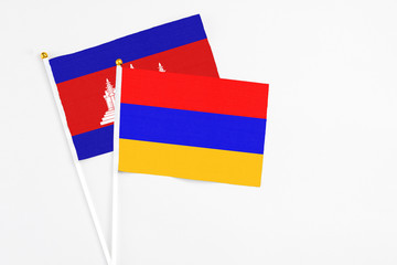 Armenia and Cambodia stick flags on white background. High quality fabric, miniature national flag. Peaceful global concept.White floor for copy space.