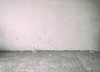 The old and dirty concrete floor and gray wall indoor the abandoned house