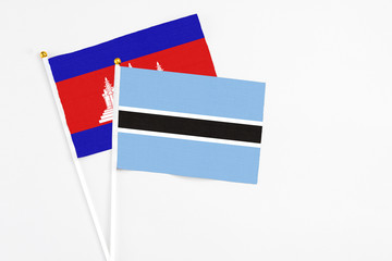 Botswana and Cambodia stick flags on white background. High quality fabric, miniature national flag. Peaceful global concept.White floor for copy space.