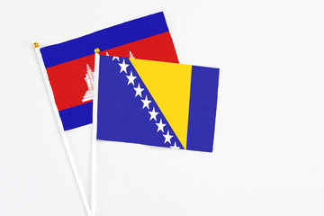Bosnia Herzegovina and Cambodia stick flags on white background. High quality fabric, miniature...