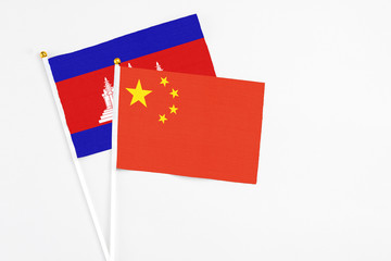 China and Cambodia stick flags on white background. High quality fabric, miniature national flag. Peaceful global concept.White floor for copy space.