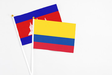 Colombia and Cambodia stick flags on white background. High quality fabric, miniature national...