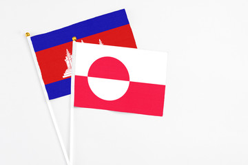 Greenland and Cambodia stick flags on white background. High quality fabric, miniature national...