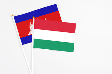 Hungary and Cambodia stick flags on white background. High quality fabric, miniature national flag. Peaceful global concept.White floor for copy space.