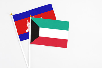 Kuwait and Cambodia stick flags on white background. High quality fabric, miniature national flag. Peaceful global concept.White floor for copy space.