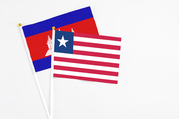 Liberia and Cambodia stick flags on white background. High quality fabric, miniature national flag....