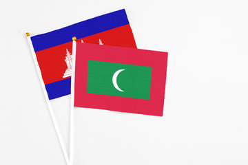 Maldives and Cambodia stick flags on white background. High quality fabric, miniature national flag. Peaceful global concept.White floor for copy space.