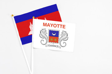 Mayotte and Cambodia stick flags on white background. High quality fabric, miniature national flag. Peaceful global concept.White floor for copy space.