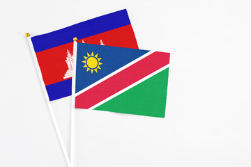 Namibia and Cambodia stick flags on white background. High quality fabric, miniature national flag. Peaceful global concept.White floor for copy space.