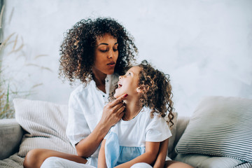 Beautiful woman with cute girl on sofa