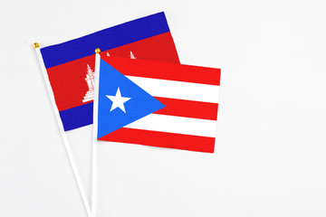 Puerto Rico and Cambodia stick flags on white background. High quality fabric, miniature national flag. Peaceful global concept.White floor for copy space.