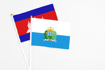 San Marino and Cambodia stick flags on white background. High quality fabric, miniature national...