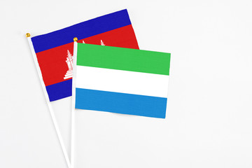 Sierra Leone and Cambodia stick flags on white background. High quality fabric, miniature national flag. Peaceful global concept.White floor for copy space.