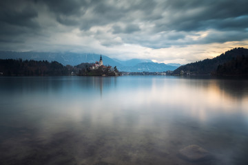 Fototapeta na wymiar Amazing colorful view of Bled lake with St. Marys Church of the Assumption on the small island and mountains in the background at sunset
