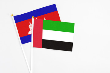 United Arab Emirates and Cambodia stick flags on white background. High quality fabric, miniature national flag. Peaceful global concept.White floor for copy space.