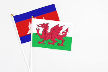 Wales and Cambodia stick flags on white background. High quality fabric, miniature national flag....