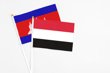 Yemen and Cambodia stick flags on white background. High quality fabric, miniature national flag. Peaceful global concept.White floor for copy space.