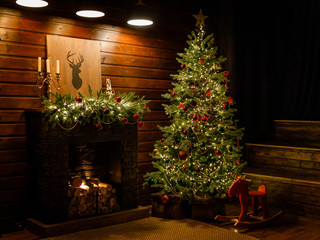 Christmas and New Year interior - blur background: fireplace, lamps, green Christmas tree, brown...