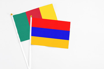 Armenia and Cameroon stick flags on white background. High quality fabric, miniature national flag. Peaceful global concept.White floor for copy space.