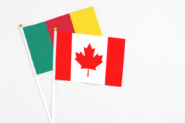 Canada and Cameroon stick flags on white background. High quality fabric, miniature national flag. Peaceful global concept.White floor for copy space.