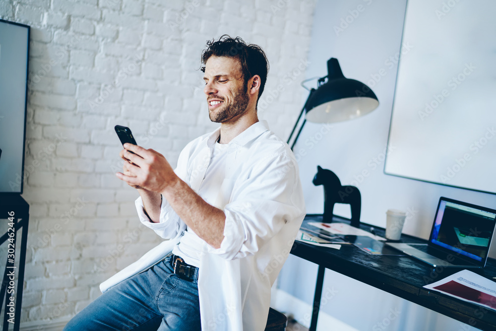 Poster cheerful caucasian man satisfied with tariffs for 4g internet connection on mobile phone, smiling hi