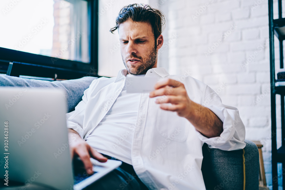 Aufkleber hipster guy sending text message to colleague while sitting with modern laptop computer, millennial 