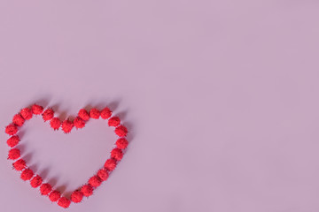 Red heart made of sticky pumpkins on a purple background. Postcard for Valentine's Day.