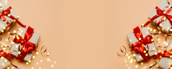 2025 Merry Christmas and New Year congratulation card with many gift boxes with gold ribbons and tinsel on a beige background with copy space.