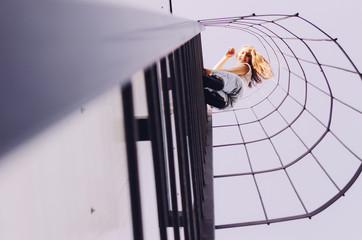 Woman climbing ladder on a roof