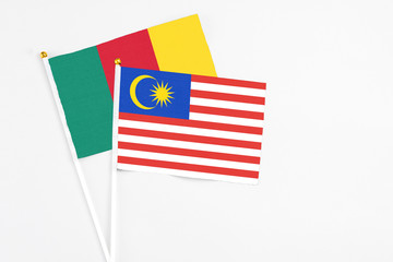 Malaysia and Cameroon stick flags on white background. High quality fabric, miniature national flag. Peaceful global concept.White floor for copy space.