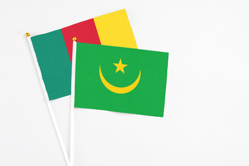 Mauritania and Cameroon stick flags on white background. High quality fabric, miniature national flag. Peaceful global concept.White floor for copy space.