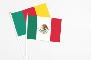 Mexico and Cameroon stick flags on white background. High quality fabric, miniature national flag. Peaceful global concept.White floor for copy space.