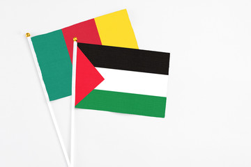 Palestine and Cameroon stick flags on white background. High quality fabric, miniature national flag. Peaceful global concept.White floor for copy space.