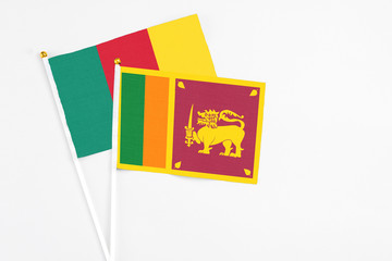 Sri Lanka and Cameroon stick flags on white background. High quality fabric, miniature national flag. Peaceful global concept.White floor for copy space.